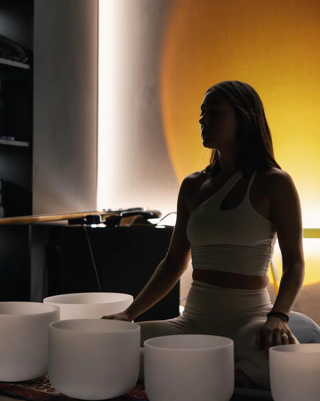 Alexia con cuencos de cuarzo en luz cálida